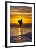 Uk, Cornwall, Polzeath. a Woman Comes in from an Evening Surf Against a Stunning Sunset.-Niels Van Gijn-Framed Photographic Print