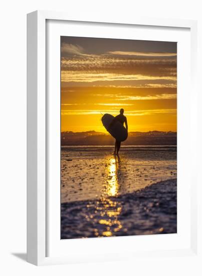 Uk, Cornwall, Polzeath. a Woman Comes in from an Evening Surf Against a Stunning Sunset.-Niels Van Gijn-Framed Photographic Print