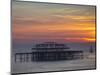 UK, England, Sussex, Brighton, Boat Sailing Past Remains of Brighton West Pier at Sunset-Jane Sweeney-Mounted Photographic Print