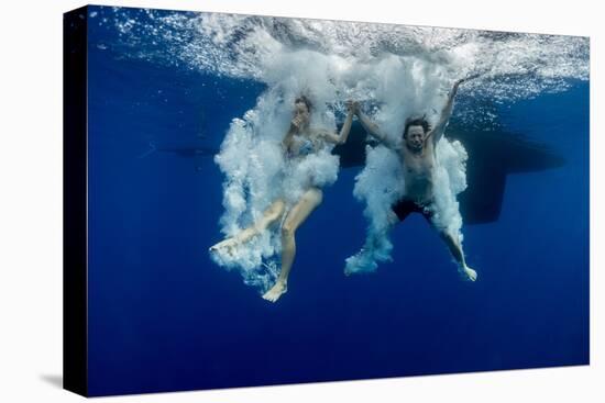 Underwater View of the Young Couple Having Fun and Jumping into the Clear Sea from a Boat-Dudarev Mikhail-Stretched Canvas