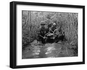 US Soldiers Carry a Wounded Comrade Through a Swampy Area in Vietnam, 1969-null-Framed Photo