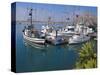 USA, California. Docked boats at Morro Bay with Morro Rock behind.-Anna Miller-Stretched Canvas