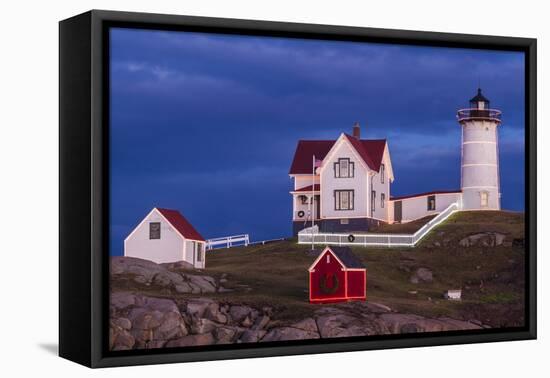 USA, Maine, York Beach, Nubble Light Lighthouse with Christmas decorations at dusk-Walter Bibikow-Framed Stretched Canvas