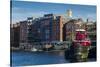 USA, New Hampshire, Portsmouth, waterfront buildings with tugboat-Walter Bibikow-Stretched Canvas