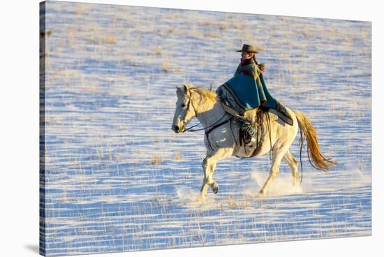 USA, Shell, Wyoming. Hideout Ranch cowgirl riding her horse in the snow. (PR,MR)-Darrell Gulin-Stretched Canvas