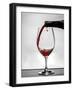 USA, Washington, Spokane. Red wine poured into wine glass creates perfect round drop,-Richard Duval-Framed Photographic Print