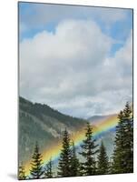 Usa, Washington State, Crystal Mountain. Rainbow in valley through trees.-Merrill Images-Mounted Photographic Print
