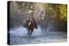 USA, Wyoming, Shell, The Hideout Ranch, Cowboy and Cowgirl on Horseback Running through the River-Hollice Looney-Stretched Canvas