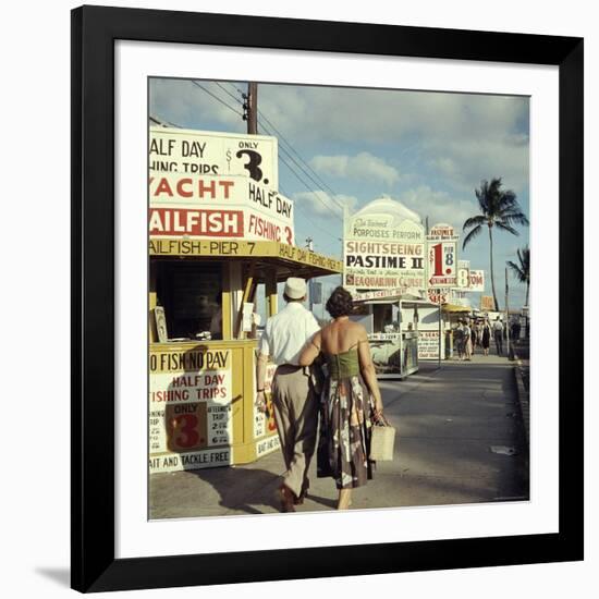 Vacationers Walking by Booths Advertising Boat Tours-Hank Walker-Framed Photographic Print