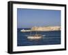 Valletta, A Fishing Boat Motors Out of the Entrance to the Grand Harbour Past Ricasoli Point, Malta-John Warburton-lee-Framed Photographic Print