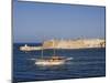 Valletta, A Fishing Boat Motors Out of the Entrance to the Grand Harbour Past Ricasoli Point, Malta-John Warburton-lee-Mounted Photographic Print