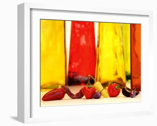 Various Types of Peppers in Front of Red & Yellow Bottles-Monica Varella-Framed Photographic Print