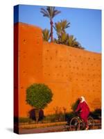 Veiled Woman Bicycling Below Red City Walls, Marrakech, Morocco-Merrill Images-Stretched Canvas