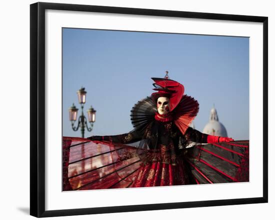 Venice, Veneto, Italy, a Mask in Costume on the Bacino Di San Marco with the Cupola of Santa Maria -Ken Scicluna-Framed Photographic Print