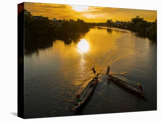 Vietnam. Coordinated lagoon fishing with nets at sunset.-Tom Norring-Stretched Canvas