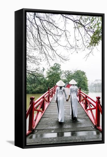 Vietnam, Hanoi, Hoan Kiem Lake. Walking on Huc Bridge in Traditional Ao Dai Dress-Matteo Colombo-Framed Stretched Canvas