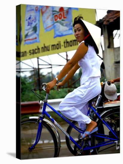 Vietnamese woman cycles in white clothes and hat-Charles Bowman-Stretched Canvas