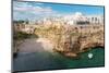 View of beach and old town on limestone cliffs, Polignano a Mare, Puglia, Italy, Europe-Karen Deakin-Mounted Photographic Print