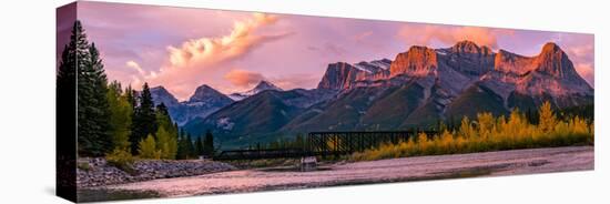 View of rail bridge over river and Three Sisters Mountain Canmore, Alberta, Canada-Panoramic Images-Stretched Canvas