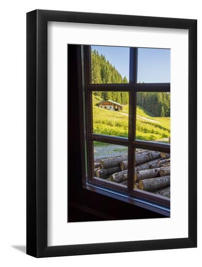 View out a window toward a cabin nestled in the hills of the Austrian Alps-Sheila Haddad-Framed Photographic Print