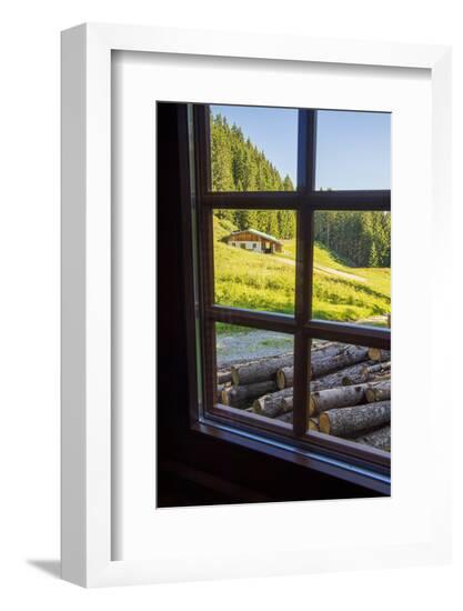 View out a window toward a cabin nestled in the hills of the Austrian Alps-Sheila Haddad-Framed Photographic Print