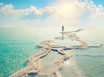 Silhouette of Young Woman Walking on Dead Sea Salt Shore at Sunrise towards the Sun-vvvita-Photographic Print