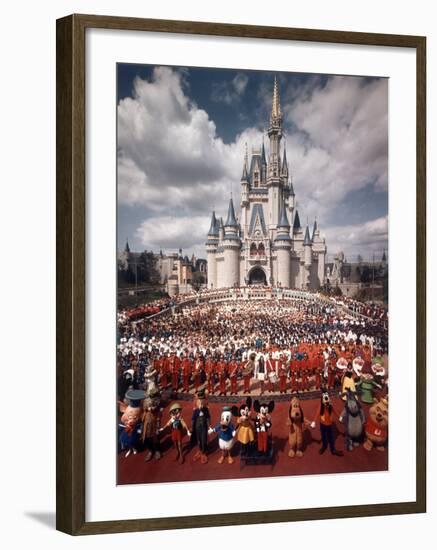 Walt Disney Characters and Park Staff Posing En Masse in Front of Cinderella's Castle-Yale Joel-Framed Photographic Print