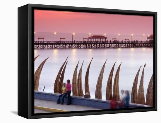 Waterfront Scene at Huanchaco in Peru, Locals Relax Next to Totora Boats Stacked Along the Beach-Andrew Watson-Framed Stretched Canvas