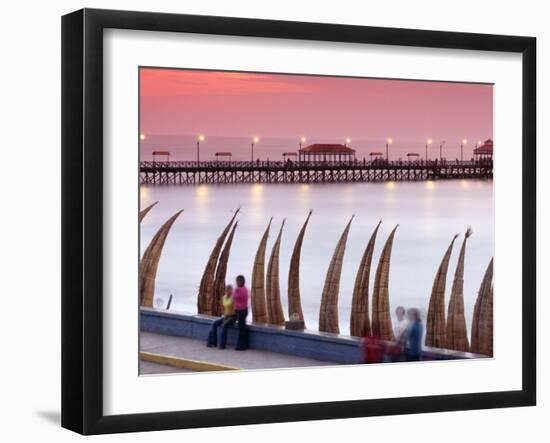 Waterfront Scene at Huanchaco in Peru, Locals Relax Next to Totora Boats Stacked Along the Beach-Andrew Watson-Framed Photographic Print