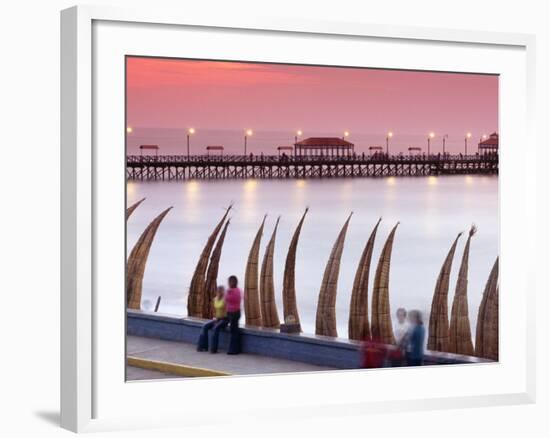 Waterfront Scene at Huanchaco in Peru, Locals Relax Next to Totora Boats Stacked Along the Beach-Andrew Watson-Framed Photographic Print