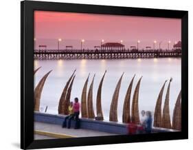 Waterfront Scene at Huanchaco in Peru, Locals Relax Next to Totora Boats Stacked Along the Beach-Andrew Watson-Framed Photographic Print