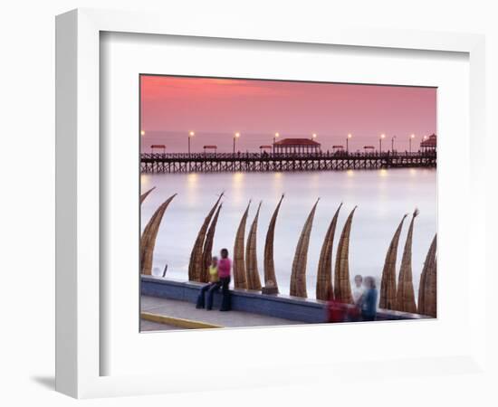 Waterfront Scene at Huanchaco in Peru, Locals Relax Next to Totora Boats Stacked Along the Beach-Andrew Watson-Framed Photographic Print