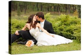 Wedding, Beautiful Young Bride Lying Together with Groom in Love on Green Grass Kissing-khorzhevska-Stretched Canvas
