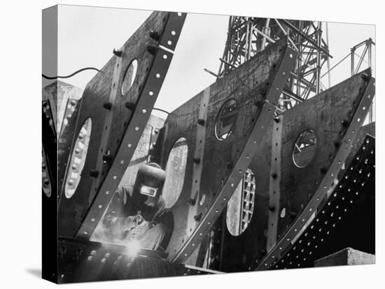 Welder Securing Steel Structure While Working on Hull of a Ship, Bethlehem Shipbuilding Drydock-Margaret Bourke-White-Stretched Canvas