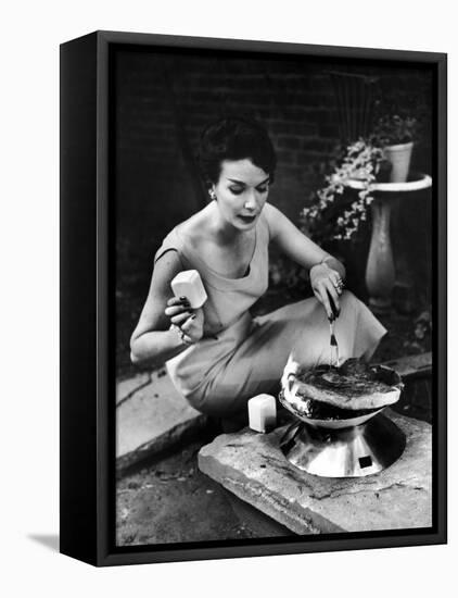 Well-Dressed Woman Cooking a Large Steak on the Aluminum Disposable Barbecue Grill-Peter Stackpole-Framed Stretched Canvas