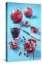 Whole and Sliced Pomegranate and Glass of Pomegranate Juice on Turquoise Wooden Table-Jana Ihle-Stretched Canvas