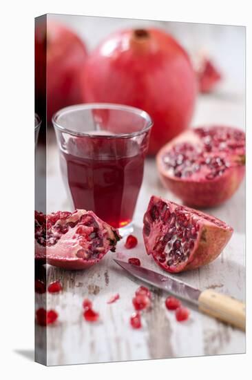 Whole and Sliced Pomegranates, Knives, Glass with Pomegranate Juice-Jana Ihle-Stretched Canvas