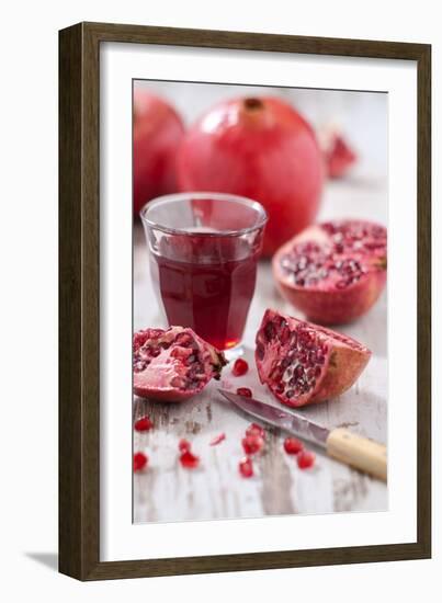 Whole and Sliced Pomegranates, Knives, Glass with Pomegranate Juice-Jana Ihle-Framed Photographic Print