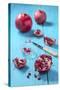 Whole and Sliced Pomegranates on Turquoise Wooden Table-Jana Ihle-Stretched Canvas