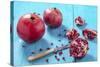 Whole and Sliced Pomegranates on Turquoise Wooden Table-Jana Ihle-Stretched Canvas
