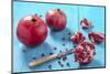 Whole and Sliced Pomegranates on Turquoise Wooden Table-Jana Ihle-Mounted Photographic Print