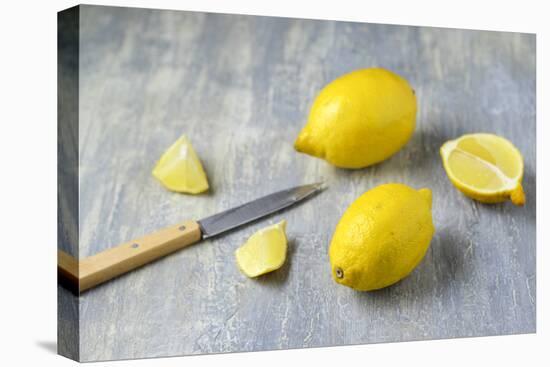 Whole Lemons, Lemon Pieces and Knife on a Gray Background-Jana Ihle-Stretched Canvas