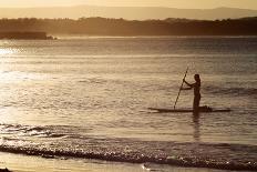 A Woman on a Stand-Up Paddleboard Heads Towards Main Beach, Noosa, at Sunset-William Gray-Photographic Print