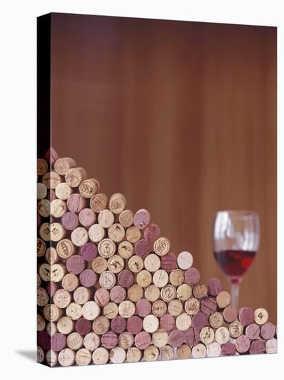 Wine Corks, Piled Up, and a Glass of Red Wine-Henrik Freek-Stretched Canvas