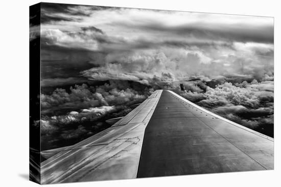 Wing of Airplane Flying in Mid-Air under and Between Clouds-Liyun Yu-Stretched Canvas