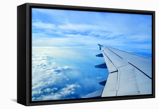 Wing of an Airplane Flying Above the Clouds-ghoststone-Framed Stretched Canvas