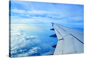 Wing of an Airplane Flying Above the Clouds-ghoststone-Stretched Canvas