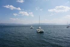 Several Sailboats Floating in the Ocean with Mountains and Clouds in the Background-Wirestock-Photographic Print