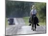 With a Buggy Approaching in the Distance, an Amish Boy Heads Down a Country Road on His Pony-Amy Sancetta-Mounted Photographic Print