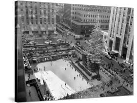 With the Famed Rockefeller Center Christmas Tree Rising Above Them, Skaters Glide on the Ice-null-Stretched Canvas